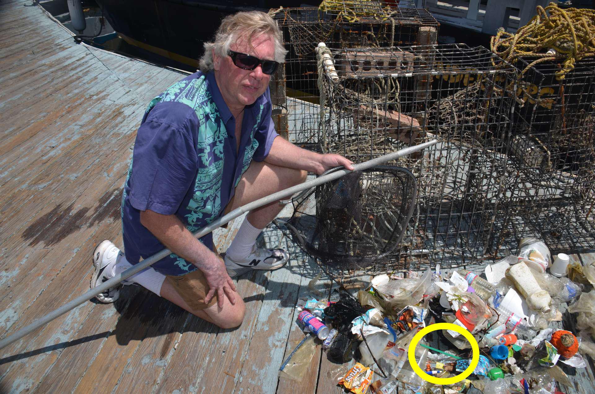 Ocean Defender Kurt Lieber on dock with debris hauled in, including plastic straw (see circle)