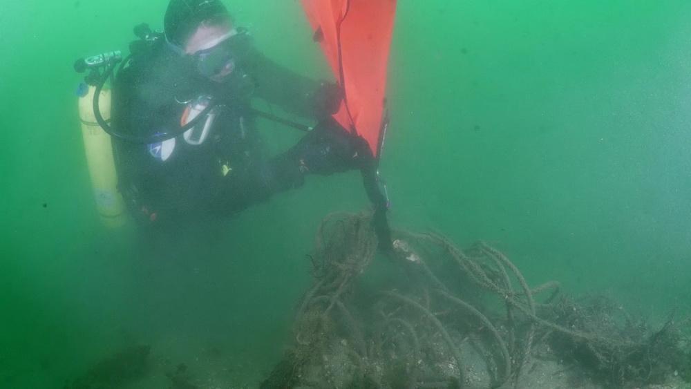 Ocean Defender volunteer connects lift bag to ghost gear