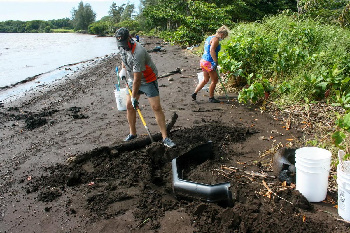 Digging up trash on Hawaii beach