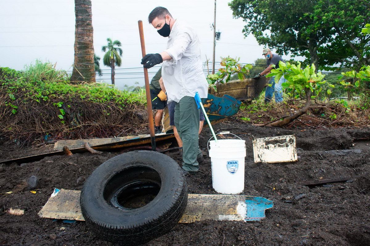 Volunteer works on removing toxic tire